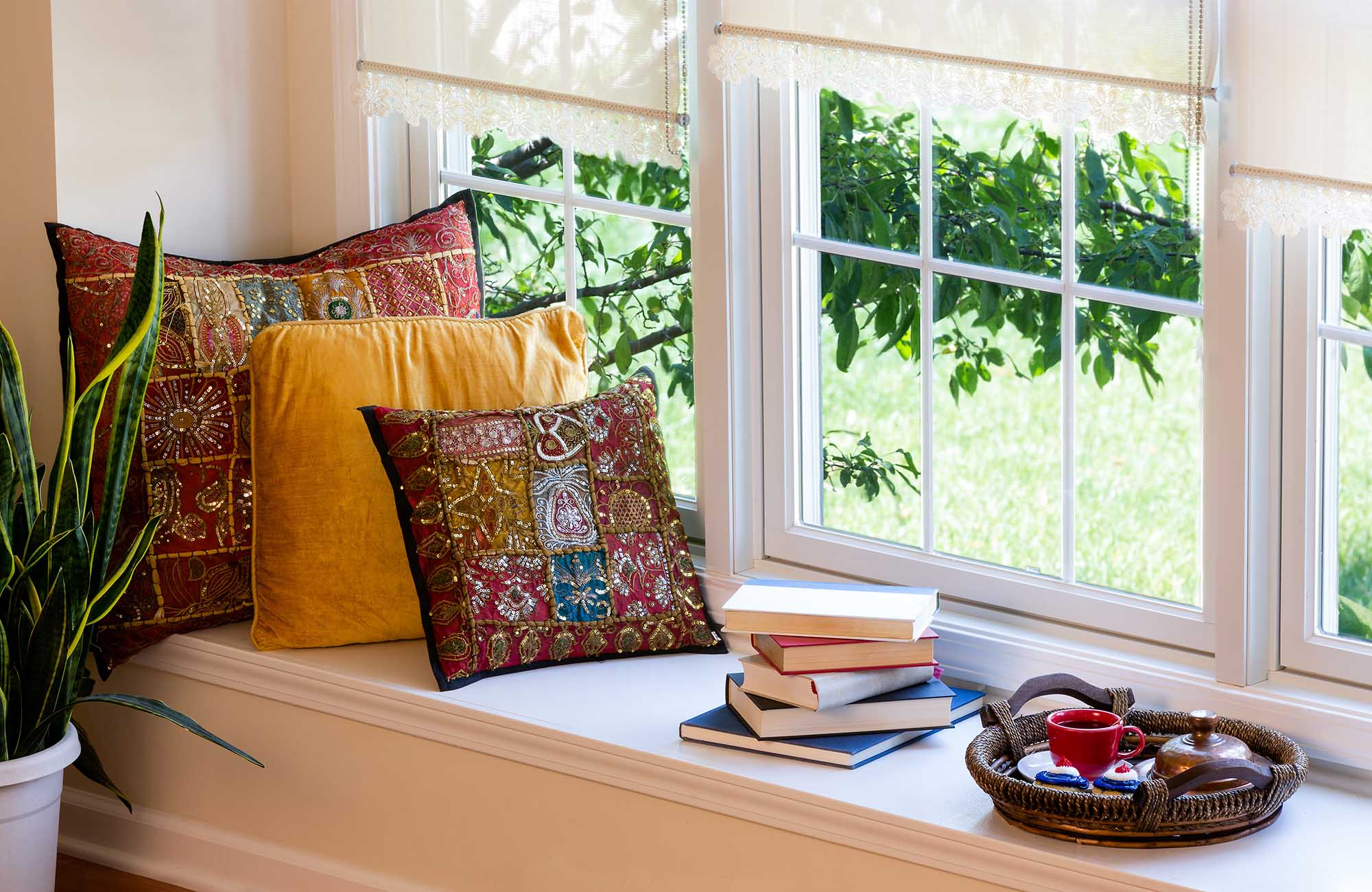 Cup of Coffee on a Tray, Piled Books and Square Pillows at the Reading Corner Inside the House.