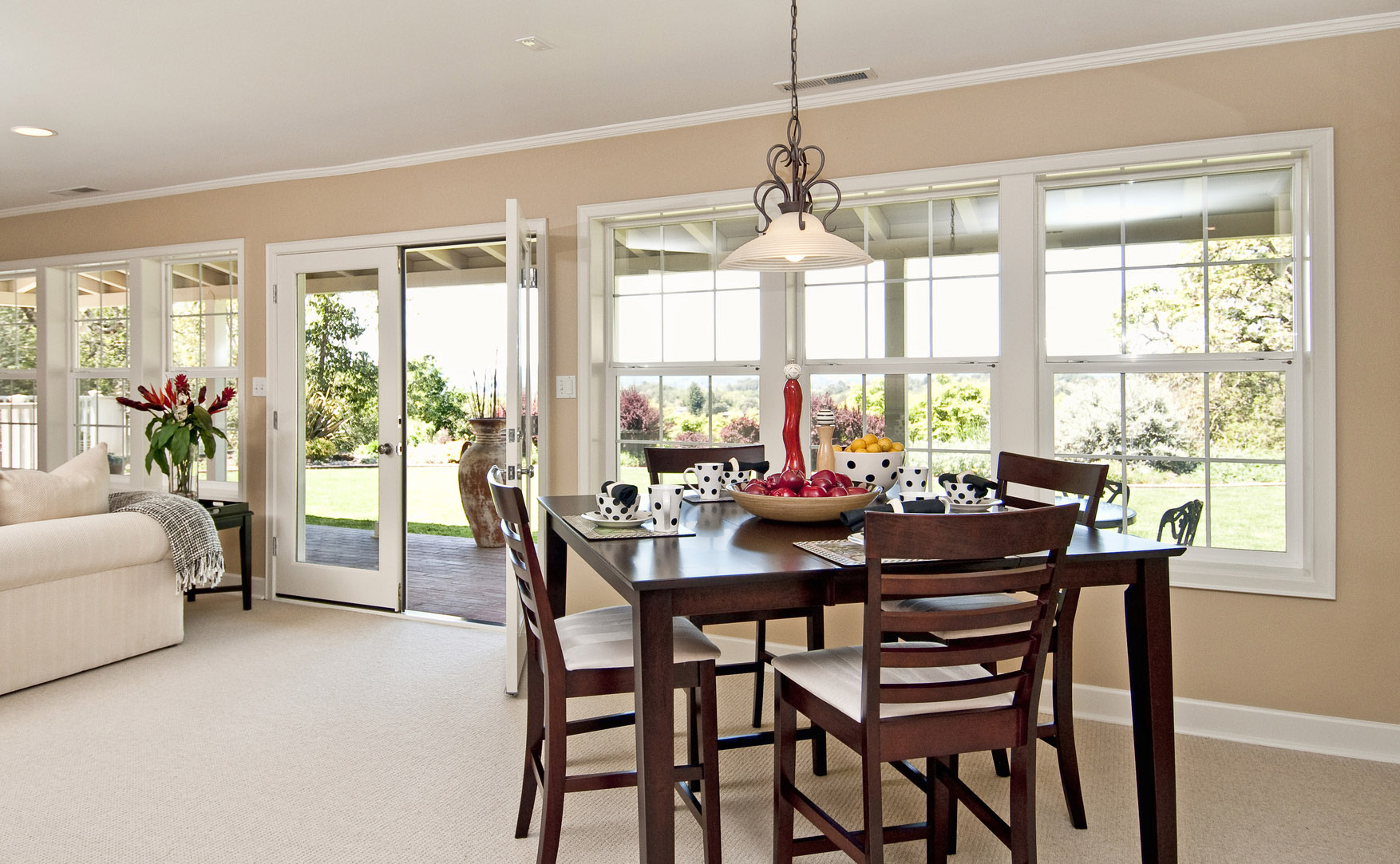 Dinning area with large window views, nice wooden table with table settings, french doors