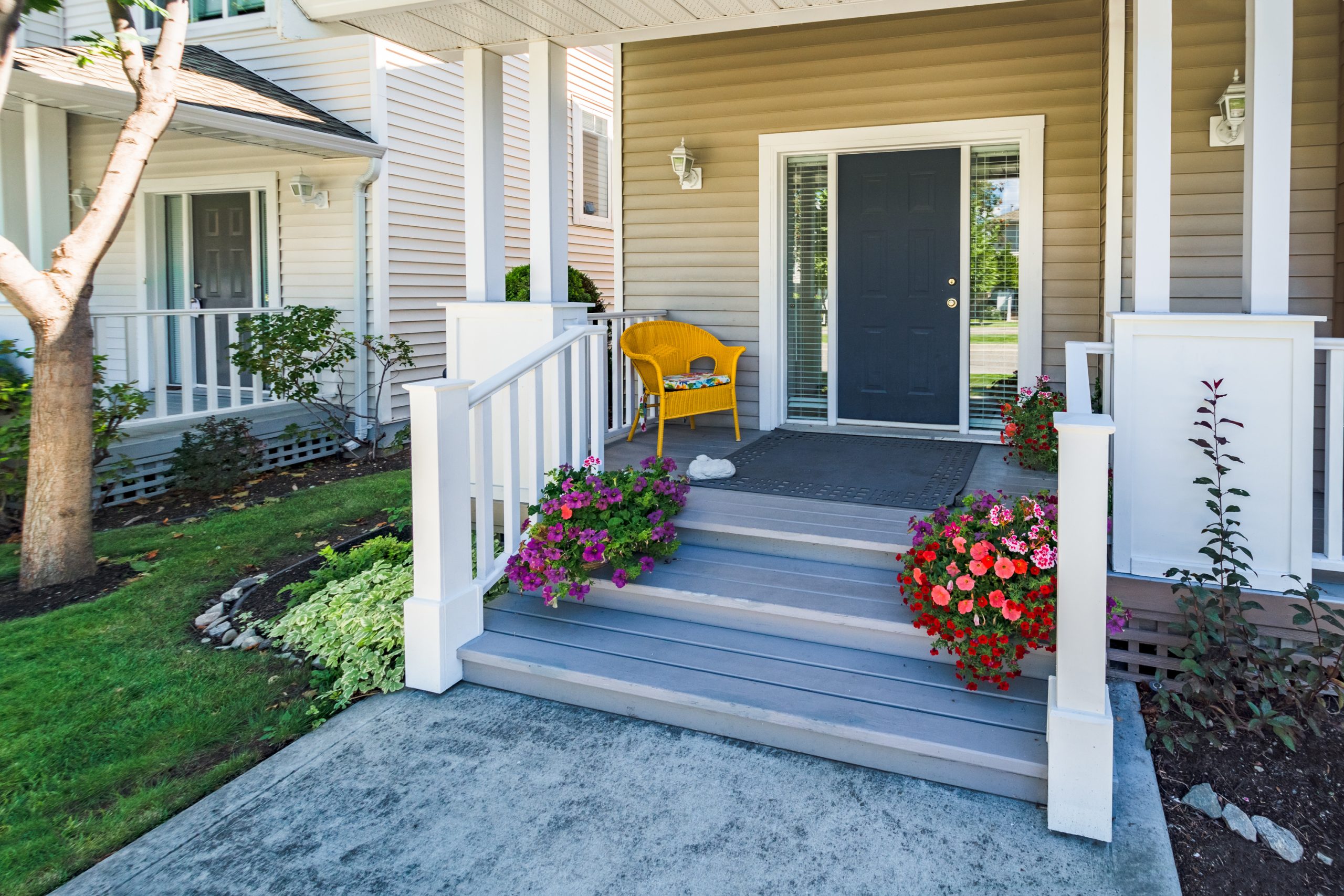 Door steps and concrete pathway leading to residential house main entrance under the porch