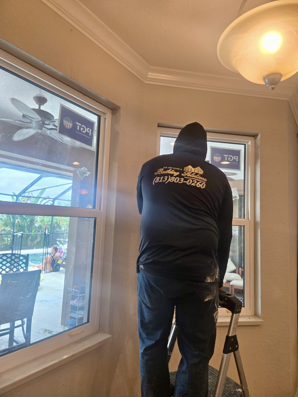 Top Tier Home Building Solutions installing hurricane-impact replacement windows in a Tampa Bay home