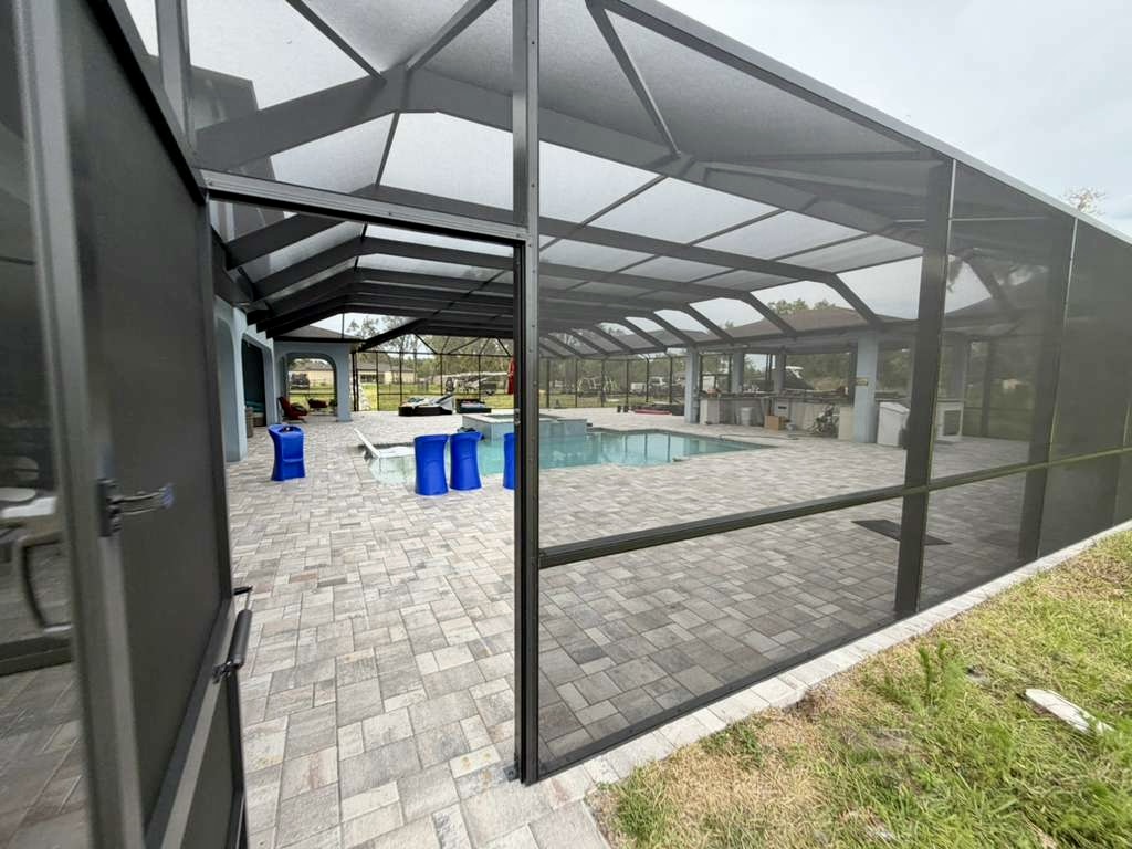 Pool cage corner and screen panel detail showing frame condition in Brooksville, FL — licensed contractor #CGC1527718