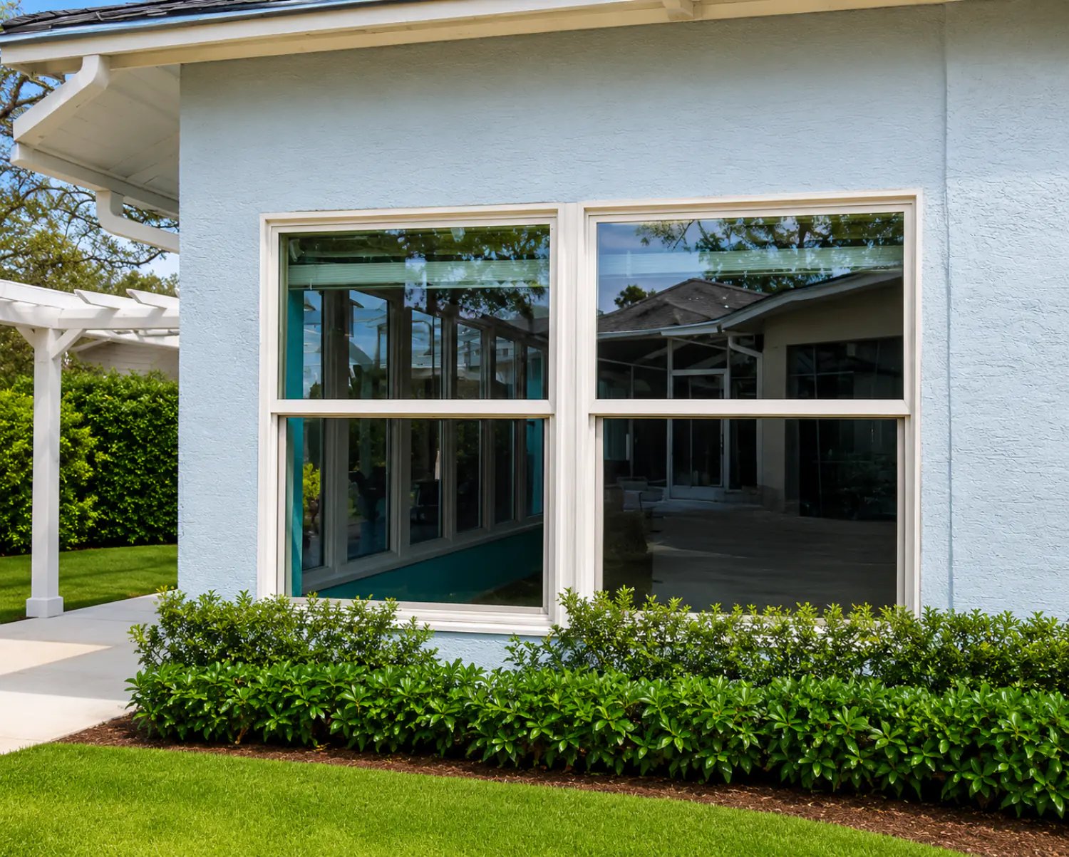 Pair of white-frame hurricane impact single-hung windows installed on a Florida home exterior