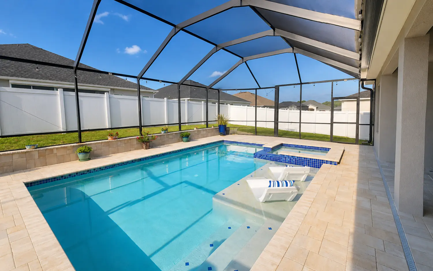 Mansard pool cage screen enclosure over a swimming pool with travertine deck and spa in Tampa Bay, Florida
